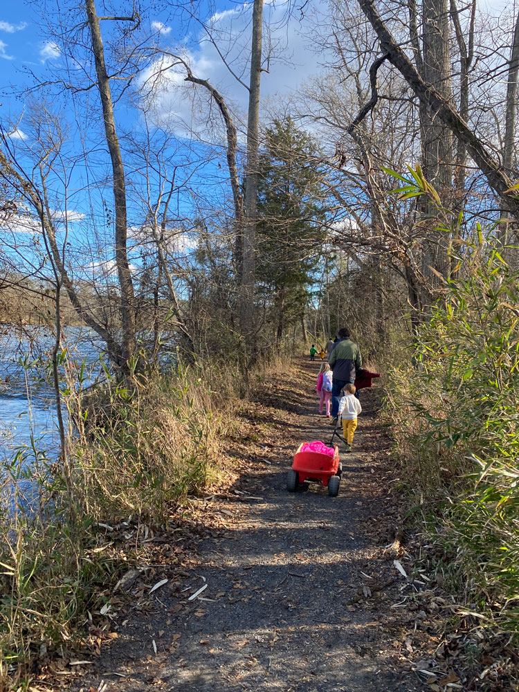 family walking trail in winter beside river